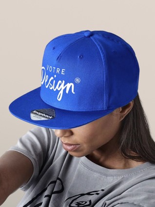 Une femme porte une casquette trucker rose imprimée d'un texte personnalisé