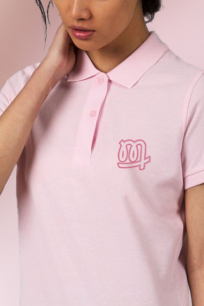 Une femme porte un polo rose personnalisé avec son logo