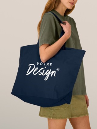 Une femme porte un tote bag écru personnalisé d'un logo