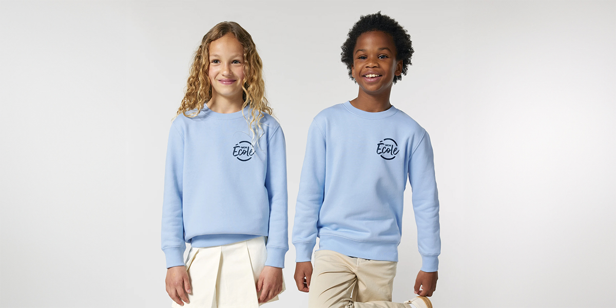 deux enfants portent le sweat mini cruiser de stanley stella pour leur uniforme scolaire