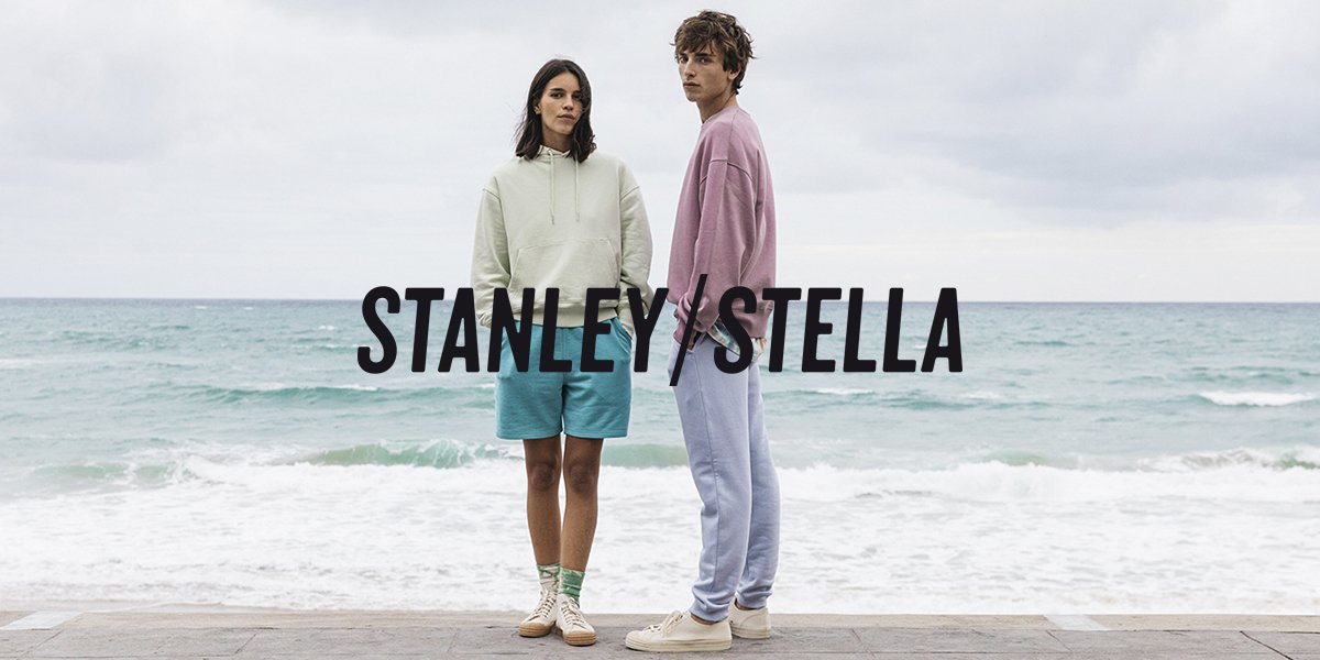 un homme et une femme avec des vêtements stanley/stella face à la mer