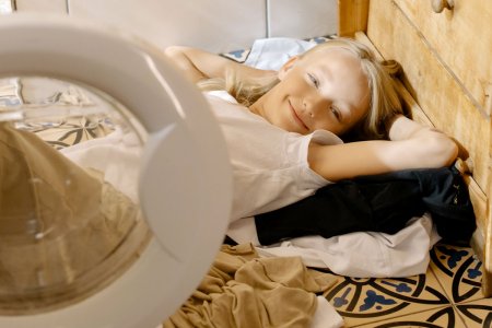 Un enfant souriant qui lave son linge personnalisé avec une machine à laver 