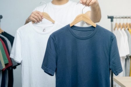 Un homme incite à choisir entre un t-shirt blanc et un t-shirt bleu