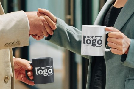 deux personnes se serrant la main avec des mugs personnalisés dans l'autre main