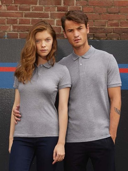 Le polo CGPM430 disponible en modèle femme, ici en coloris Heather Grey Les mannequins homme et femme portent le polo CGPM430 en coton bio à personnaliser en coloris Heather Grey