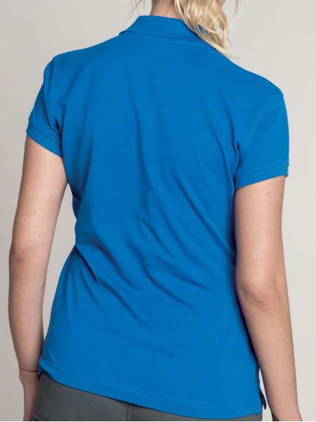Le K242 en coloris Light Royal Blue de dos à personnaliser. Le mannequin femme porte le polo K242 de dos en coloris Light Royal Blue