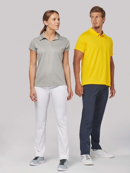 Une femme porte le polo de sport PA483 en coloris Fine Grey et un homme porte le polo PA482 en coloris Yellow