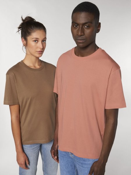 Une femme et un homme portent le t-shirt large Fuser en coloris Caramel et Rose Clay
