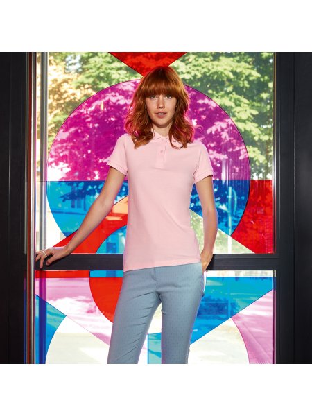 Le polo en coton 100% bio à personnaliser en coloris Orchid Pink Le mannequin femme porte le polo CGPW440 en coton bio à personnaliser en coloris Orchid Pink