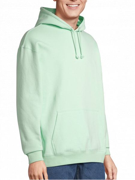 un homme de 3/4 portant le sweat condor à capuche unisexe dans le coloris vert cremeux un homme de 3/4 portant le sweat condor à capuche unisexe dans le coloris vert cremeux