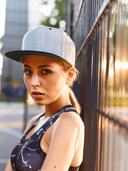 Casquette snapback bicolore Flexfit 6089MT personnalisable, portée par une femme Casquette snapback bicolore Flexfit 6089MT personnalisable, portée par une femme