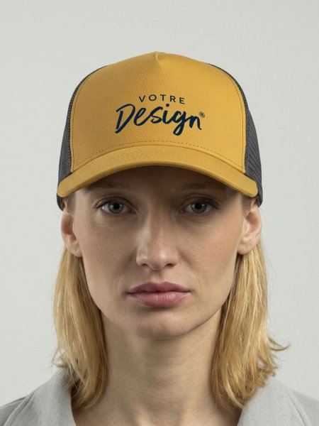 Femme portant la casquette trucker premium AT085 à personnaliser, coloris moutarde