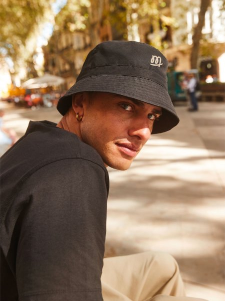 homme avec bob noir et logo beige homme avec bob noir et logo beige