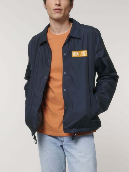 Veste recyclée Coacher en coloris French Navy Veste recyclée Coacher en coloris French Navy avec logo porté par un homme