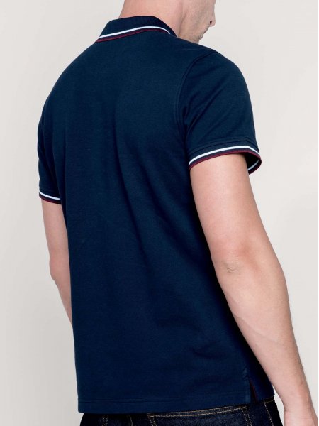 Le mannequin porte le polo à lisérés contrastés K250 de dos en coloris Navy/Wine/White.