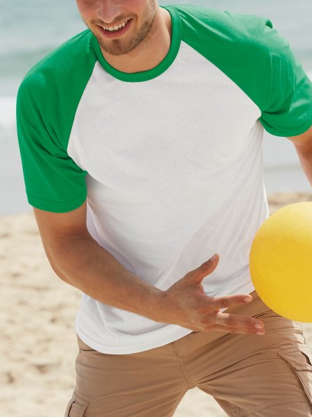 Le mannequin homme porte le t-shirt à manches raglan contrastées SC61026 à personnaliser en coloris White / Kelly Green