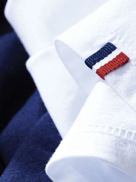 Zoom sur le détail tricolore cousu en bas de tous les t-shirts de la marque Atelier du Textile Français Zoom sur le détail tricolore cousu en bas de tous les t-shirts de la marque Atelier du Textile Français