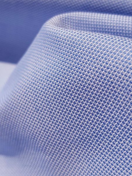 Zoom sur le tissu Oxford, mélange de fils colorés et de fils blancs qui donne un aspect quadrillé très élégant Zoom sur le tissu Oxford, mélange de fils colorés et de fils blancs qui donne un aspect quadrillé très élégant