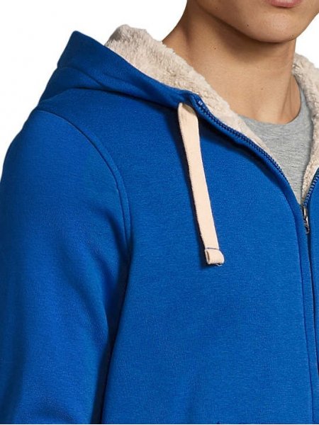 Zoom détails capuche, zip et épaule sweat Sherpa en coloris bleu royal Zoom sur les détails de la capuche, du zip et de l'épaule du sweat Sherpa en coloris bleu royal