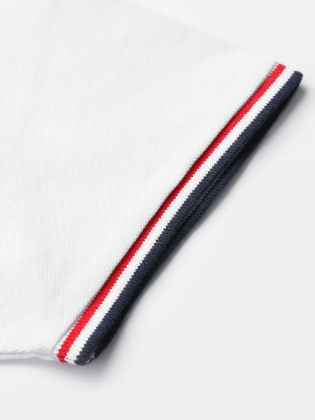 Zoom sur les liserés tricolores en bord de manche sur le polo Prestige coloris blanc Zoom sur les liserés tricolores en bord de manche sur le polo Prestige coloris blanc