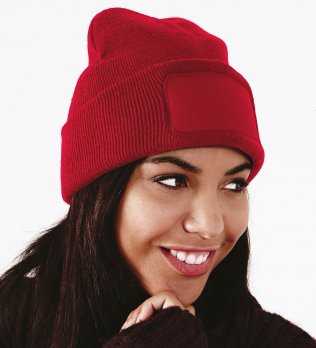 Le bonnet B445 à personnaliser en coloris Classic Red Une femme porte le bonnet patch B445 à personnaliser en coloris Classic Red