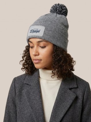 Bonnet à pompon personnalisé Snowstar Patch B443 Heather Grey / Black porté, personnalisé avec votre design brodé sur le patch