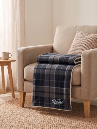 Plaid sherpa personnalisé K-Up KP431 Storm Grey / Navy checked brodé avec votre logo en coin, plié sur un fauteuil Plaid sherpa personnalisé K-Up KP431 Storm Grey / Navy checked brodé avec votre logo en coin, plié sur un fauteuil