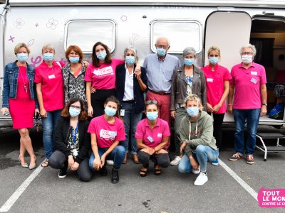 Les bénévoles de l'association Tout le monde contre le cancer posent devant la caravane où sont prodigués les soins